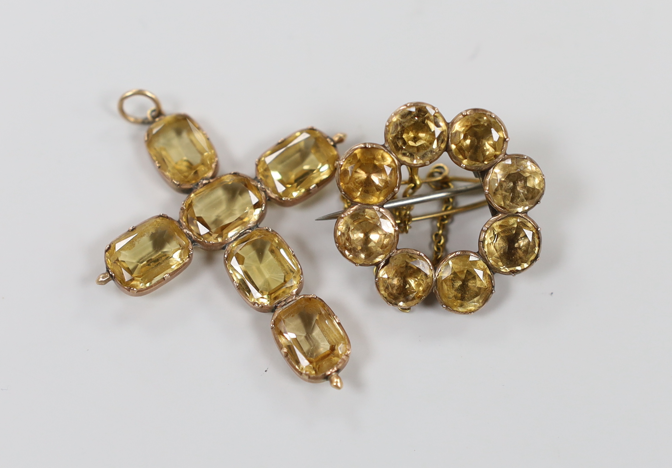 A yellow metal and six stone oval cut yellow topaz set cross pendant, 45mm and a similar eight stone set brooch, gross weight 9.4 grams.